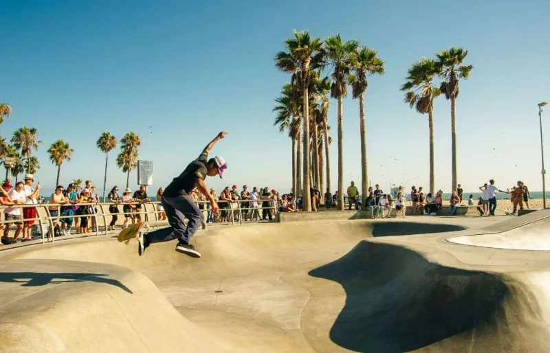 Skateur dans un skatepark de Los Angeles bordé de palmiers en Californie du Sud