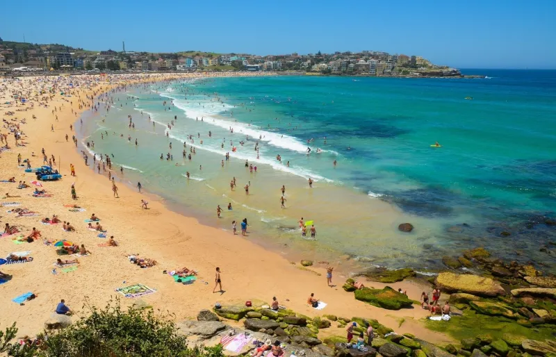 Vue panoramique de Bondi Beach à Sydney, avec ses baigneurs, ses surfeurs et son sable doré en Australie