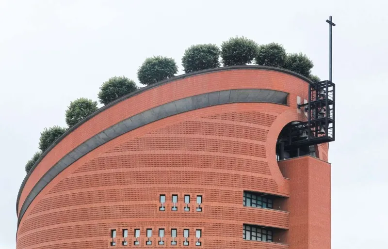 Cathédrale de la Résurrection d’Évry, édifice cylindrique en briques rouges couronné de tilleuls