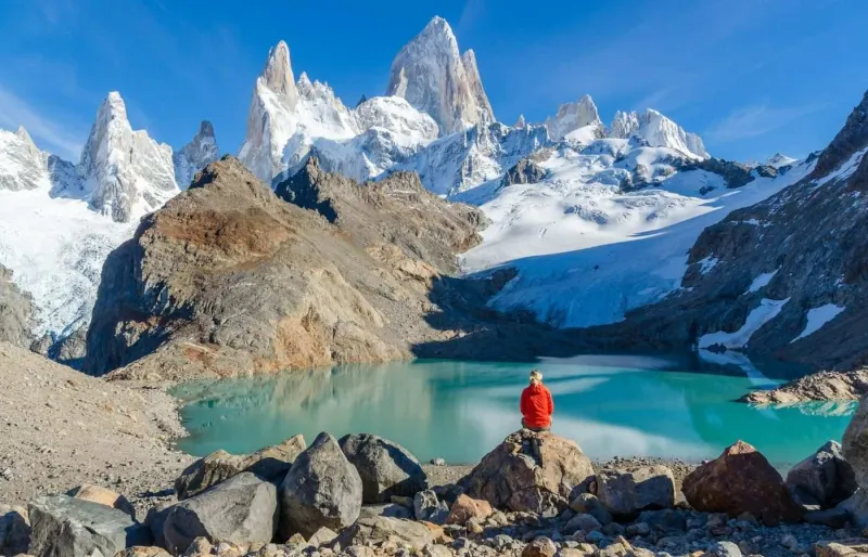 Randonneuse face au Fitz Roy et à un lac turquoise en Patagonie argentine