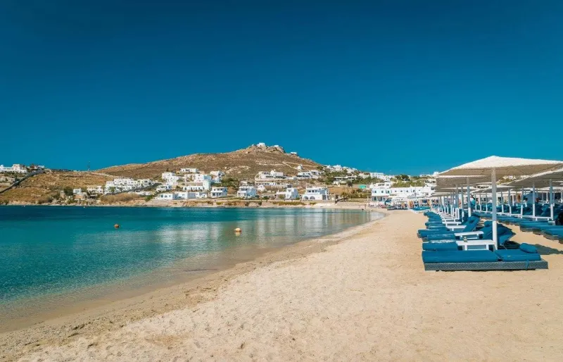 Plage d’Ornos à Mykonos avec ses eaux calmes et ses transats