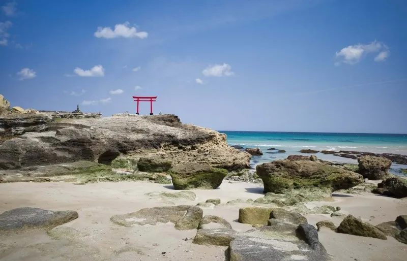 Plage de Shirahama à Shimoda, avec sa mer turquoise, sa côte rocheuse et son torii rouge