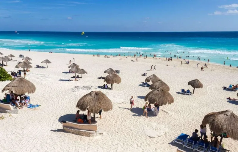 Playa Delfines à Cancún avec ses palapas et sa grande plage de sable blanc