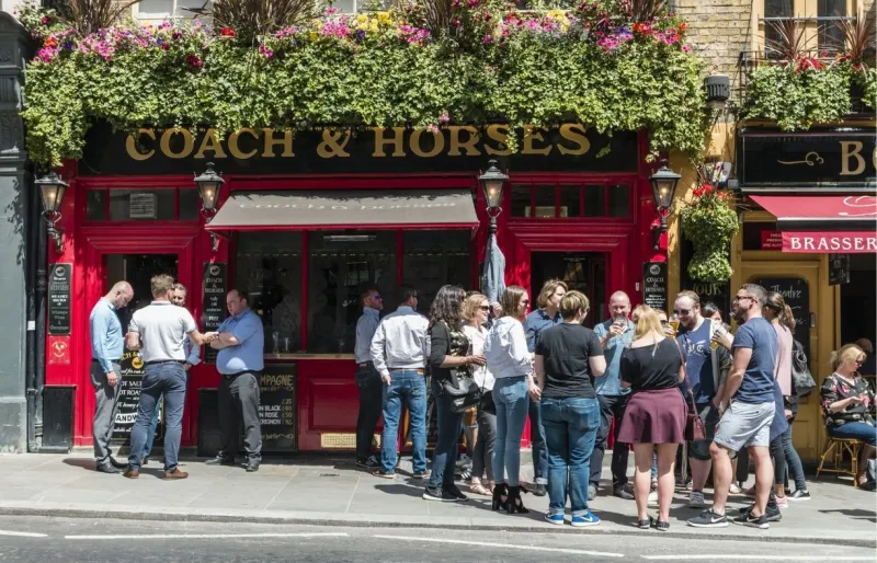 Clients buvant une bière devant un pub anglais à Londres