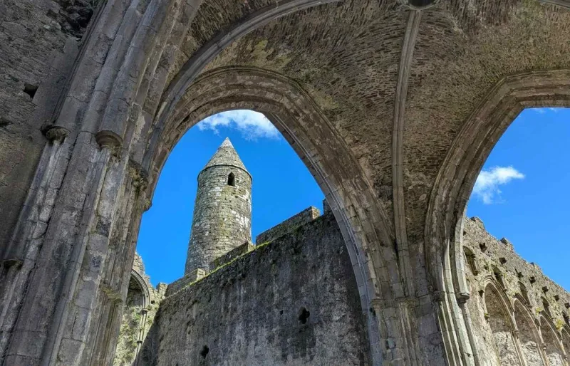 Tour ronde du Rock of Cashel vue à travers les arches gothiques des ruines, dans le comté de Tipperary en Irlande
