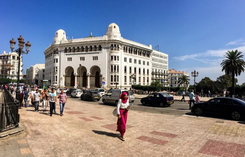 Passants dans le centre-ville d'Alger portant des tenues adaptées aux usages vestimentaires en Algérie