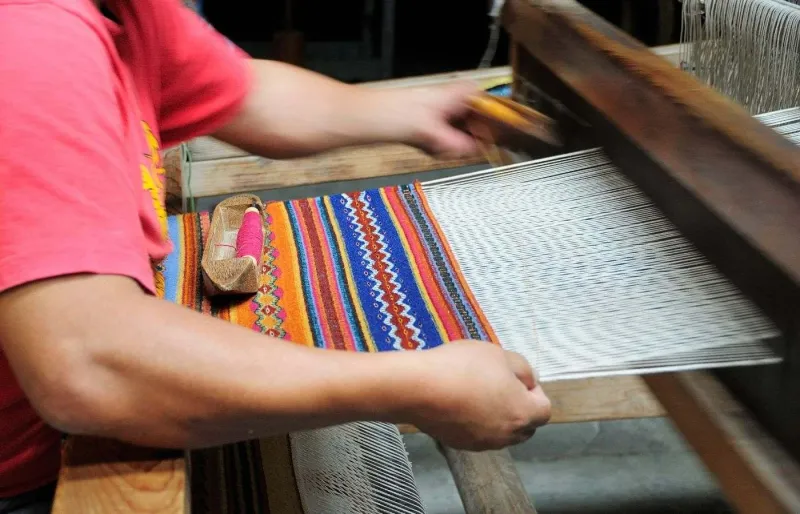 Artisan tissant un textile coloré sur un métier à tisser dans la région d’Oaxaca