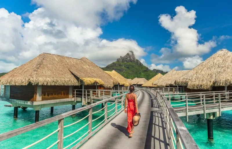 Voyageuse dans un resort avec bungalows sur pilotis à Bora Bora