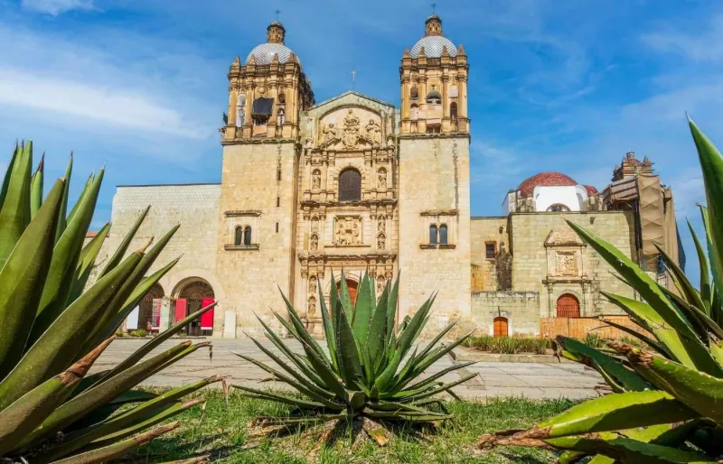 Façade de l'église Santo Domingo à Oaxaca, avec des agaves au premier plan