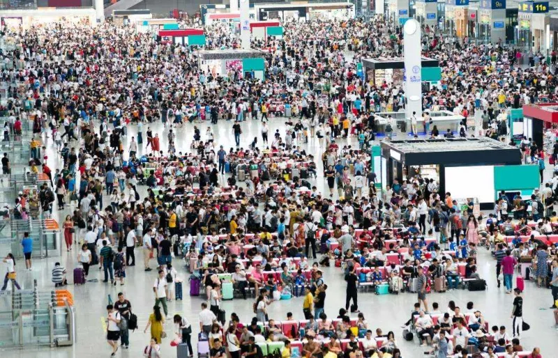 Foule de voyageurs dans le hall d’une grande gare en Chine pendant une période de forte affluence