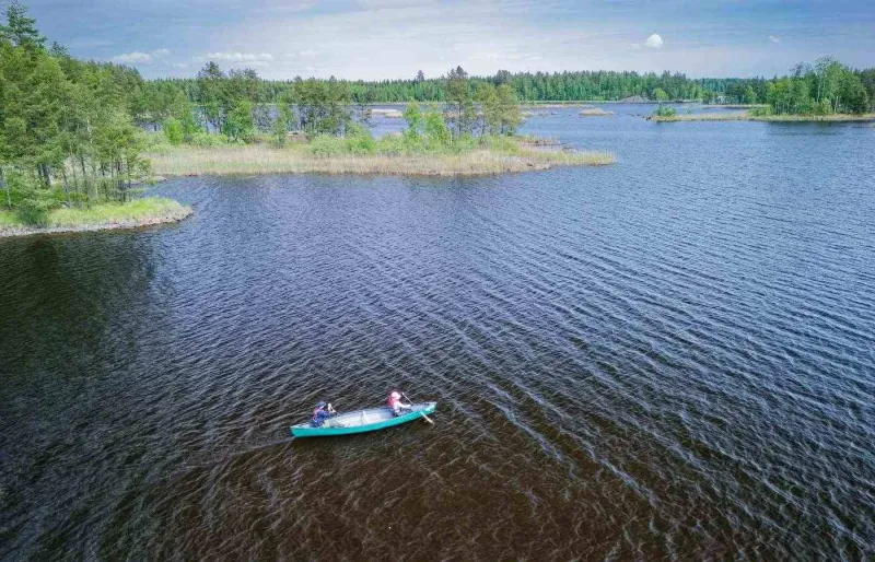 Kayak sur le lac Saimaa près d’Oravi, au milieu des îles boisées de Finlande