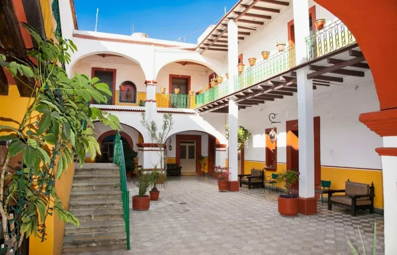 Patio d’une maison traditionnelle à Oaxaca avec arcades et balcons colorés