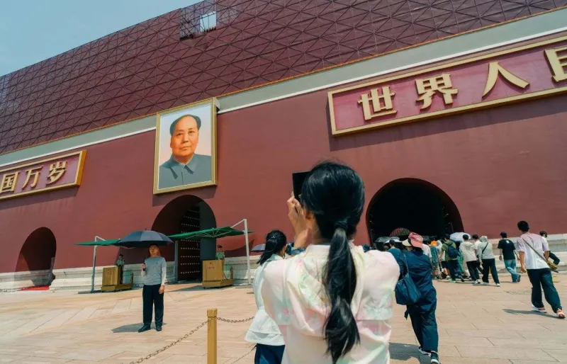 Visiteuse prenant une photo devant la porte Tian’anmen à Pékin