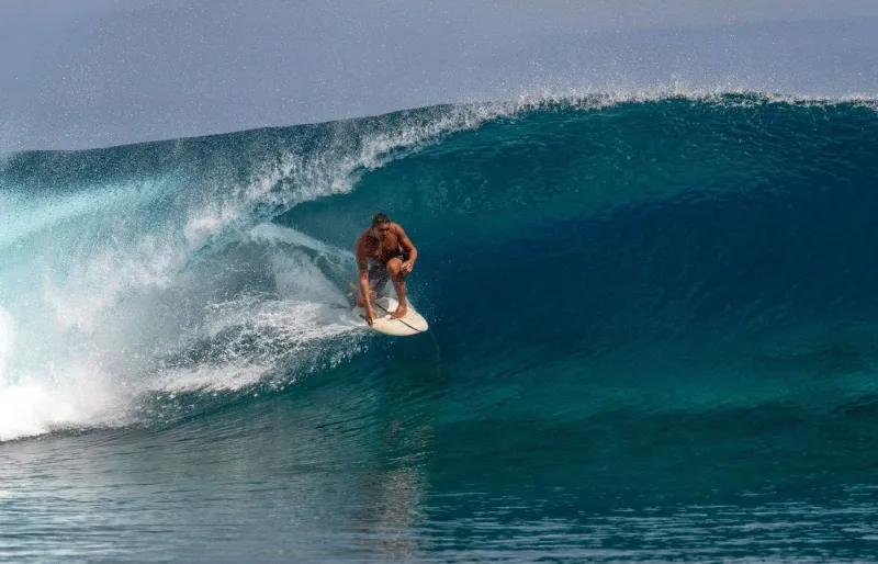 Surfeur dans une vague sur un spot de surf en Polynésie française
